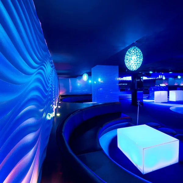 Detailed view of 3D wavy textured wall panels in blue VIP seating area of nightclub.