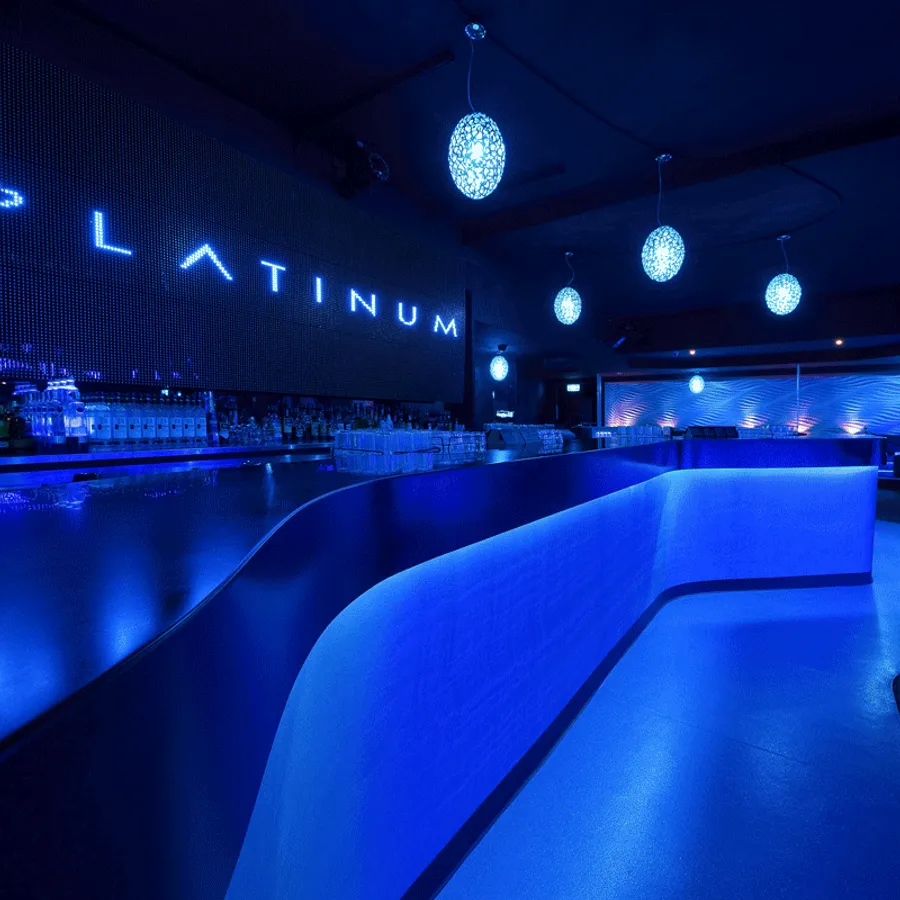 View of an upscale night club with a futuristic blue-lit bar area