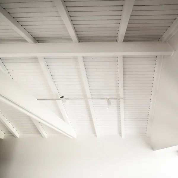 Close-up view of the main bedroom ceiling featuring exposed white timber beams and battens