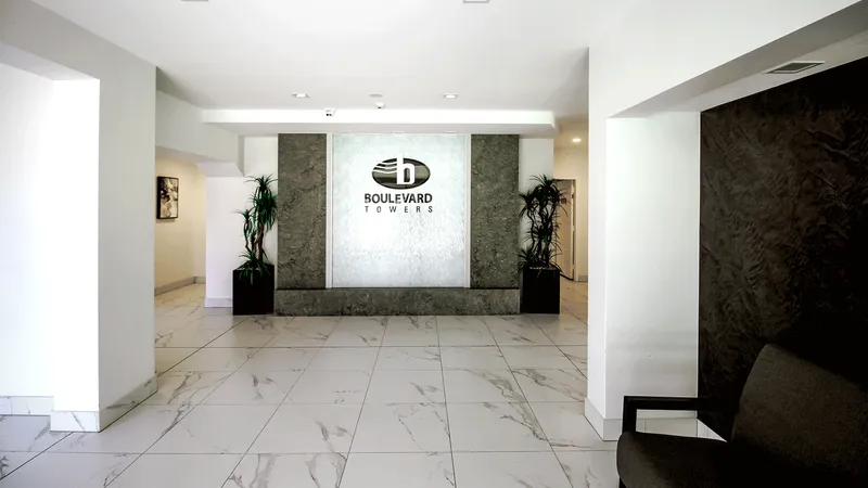 Elegant hotel lobby entryway with tiled floor, luxurious wall hangings, and contrasting dark and white elements