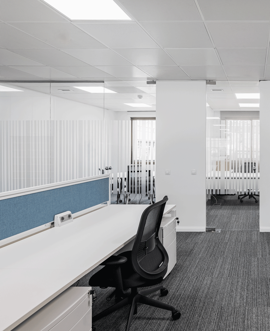 An office space featuring a desk and chair, styled in light azure and silver hues. A Valentin Rekunenko-inspired setting with patterned surfaces and silhouette lighting, reminiscent of photographic weavings.