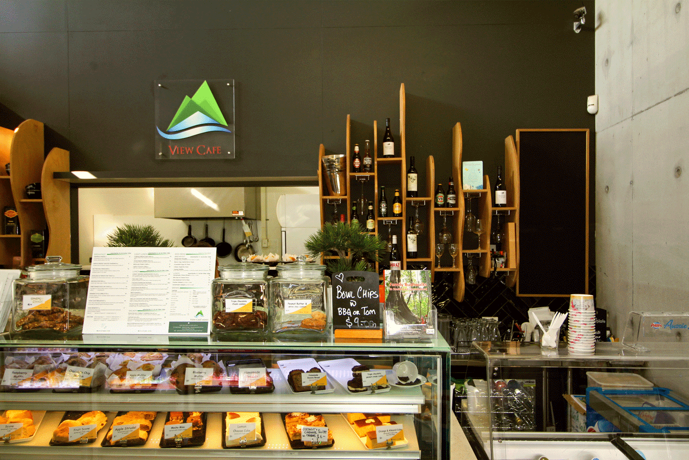An inviting cafe display case showcasing a delightful array of pastries and cakes, exuding a serene and peaceful ambiance in a vibrant, urban setting.