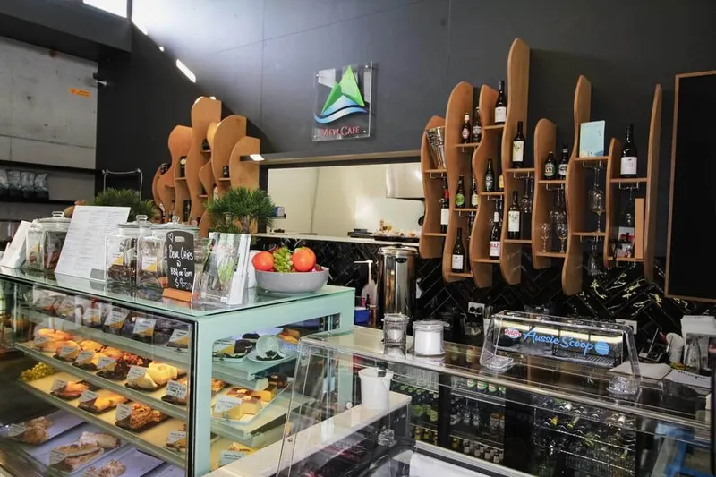 View Cafe counter area with wave-like timber display shelves and herringbone tiles