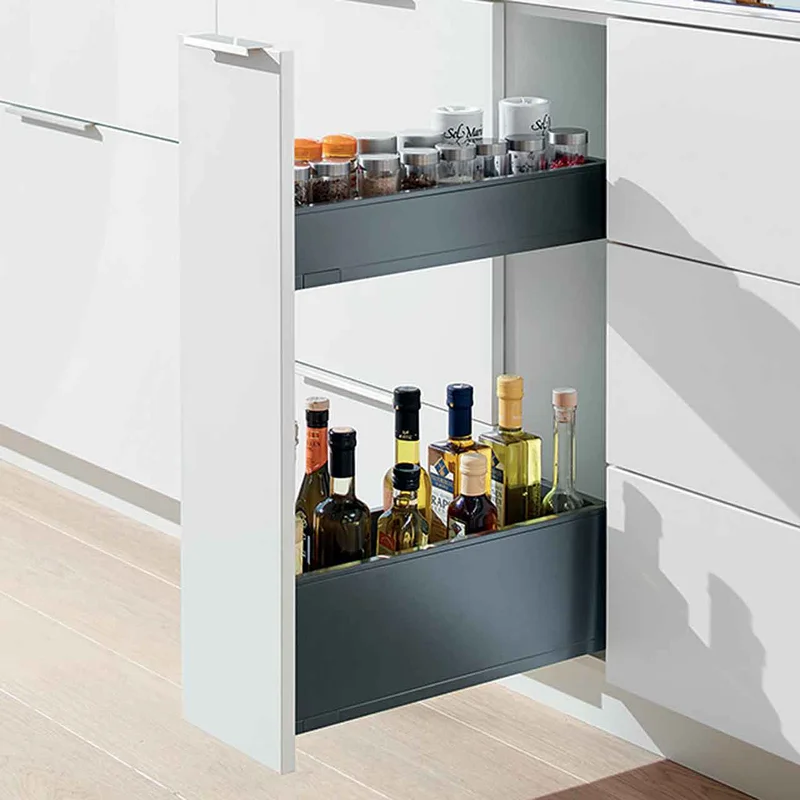 Narrow pull-out cabinet storing spices and oils next to a cooktop.