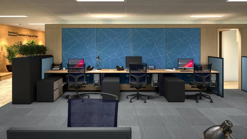 Open-plan office fitout for QBuild's South Coast Offices with four workstations, acoustic blue pinboard, and timber finishes