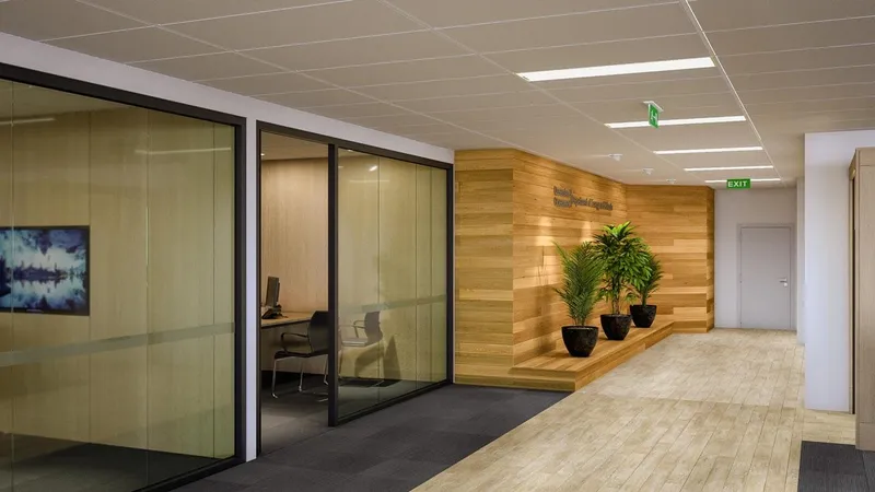Office corridor with timber feature wall, indoor plants, and glazed meeting room at QBuild's South Coast Offices.
