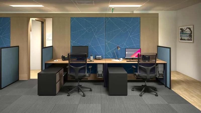 Dual workstation setup with acoustic pinboard, timber desk, and privacy screens at QBuild's South Coast Offices.
