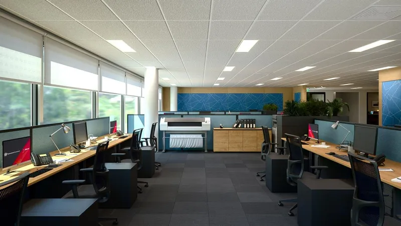 Office zone with window-facing desks, central printer station, and acoustic partitions at QBuild's South Coast Offices.